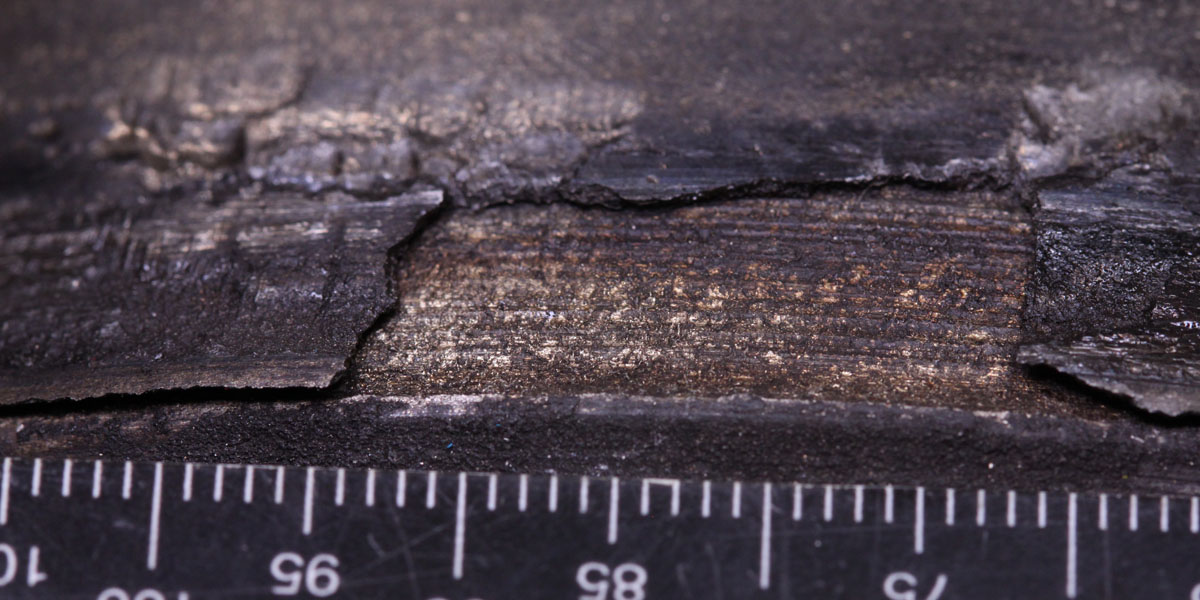 Close view of a metallic surface deposit that has flaked from the underlying steel axle